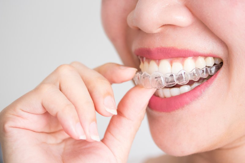 Woman putting Invisalign tray in