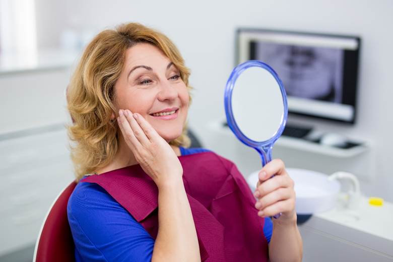 woman admiring her new smile with dental implants