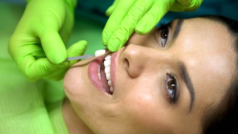 Woman having veneers placed by cosmetic dentist in Allen